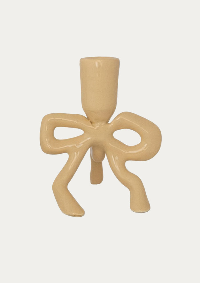 Beige candle holder with bow design on a white background