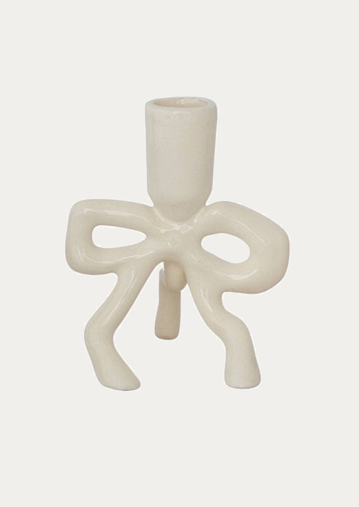 White enamel candle holder with bow design on a white background