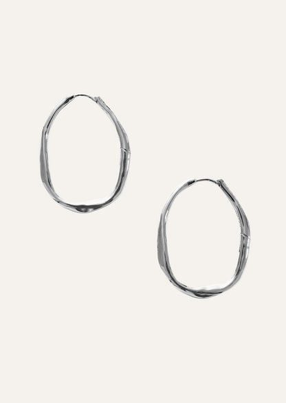 A pair of large sterling silver hoop earrings.